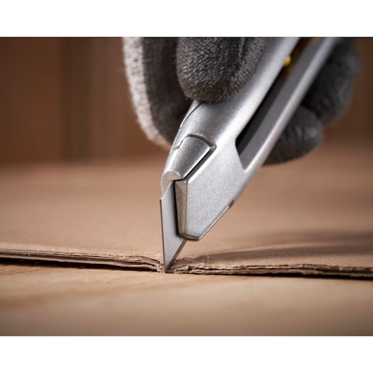 STANLEY 0-10-018 stanleymes snijdt karton, close-up, fotografie van hand met handschoen.