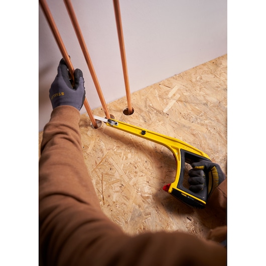 STANLEY 0-20-108 scie à métaux utilisée pour couper un tuyau en cuivre, prise de vue supérieure lors de travaux d'installation.