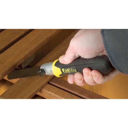 STANLEY 0-20-220 FatMax vouwzaag met zwart-gele handgreep zaagt hout, close-up tijdens gebruik.