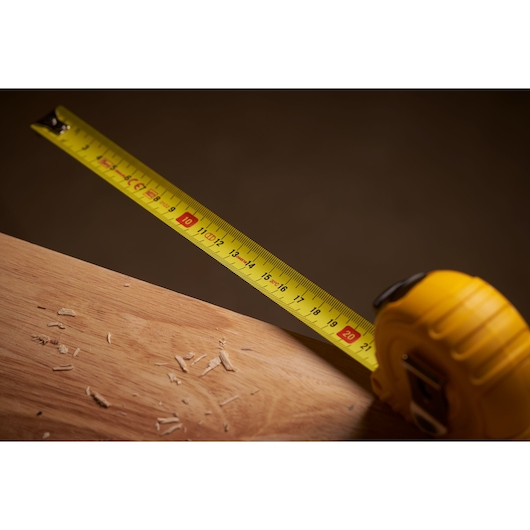 STANLEY 0-30-457 rolmaat met gele band uitgetrokken op houten oppervlak, close-up.