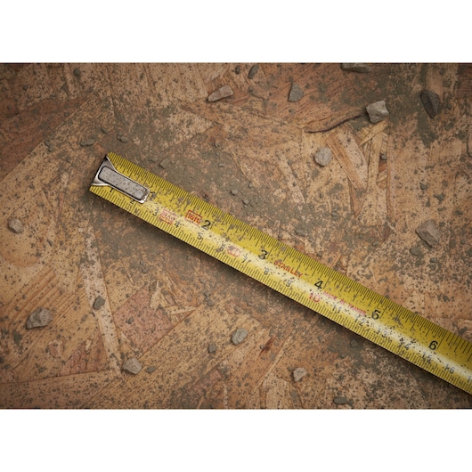 STANLEY 0-33-158 rolmaat met gele blad op stoffig houten oppervlak, diagonale weergave.