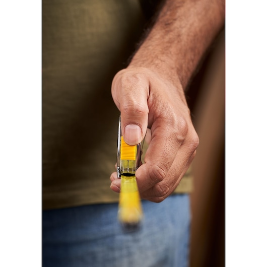 STANLEY 0-33-238 rolmaat in hand, voorkant, geel en zilver, productfotografie close-up.