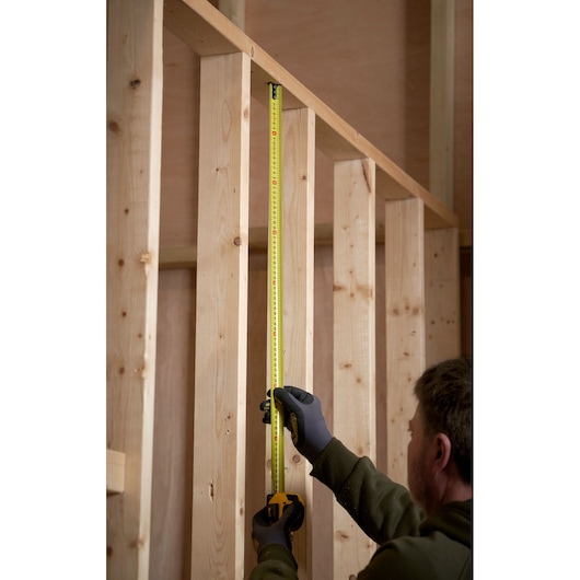 STANLEY 0-33-720 rolmaat in gebruik op houten frame, verticale meting langs houten stijlen.