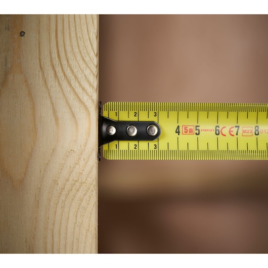 STANLEY 0-33-720 rolmaat gele blad meet houten plank, close-up zijaanzicht.