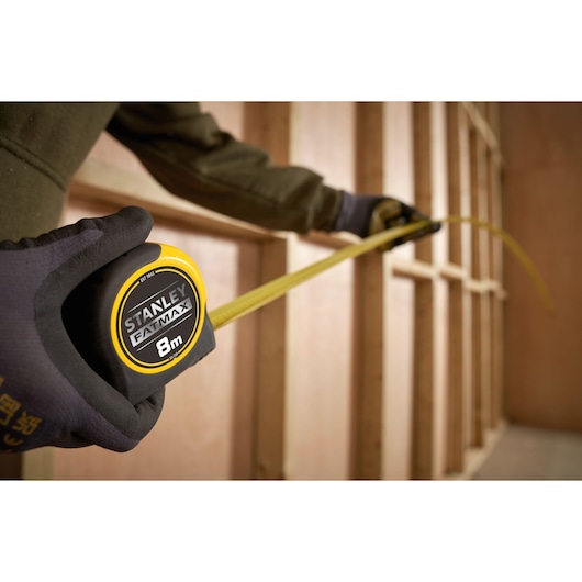 STANLEY FATMAX 8m rolmaat SKU 0-33-728 gebruikt voor het meten van houten stijlen, perspectief close-up.