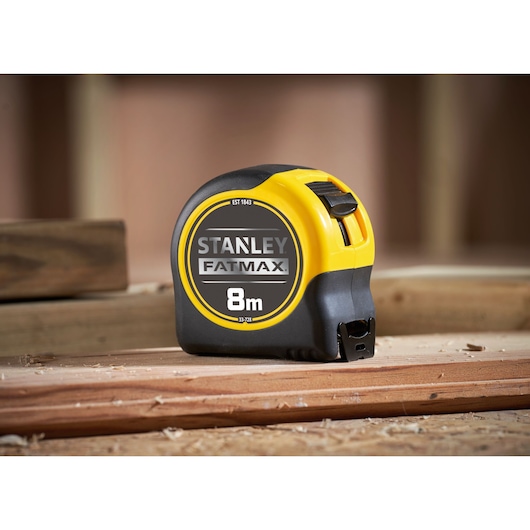 STANLEY 0-33-728 FATMAX 8m rolmaat, geel en zwart, zijaanzicht, op houten oppervlak.