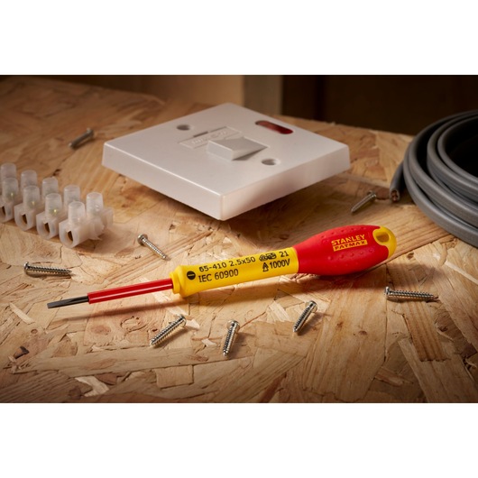 Stanley 0-65-410 elektrische schroevendraaier met rood-gele handgreep, gefotografeerd op multiplex met bedrading en schroeven.