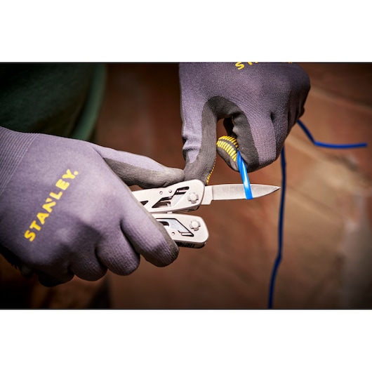 STANLEY 0-84-519 outil multifonction coupant fil bleu, gros plan, utilisé avec gants STANLEY.
