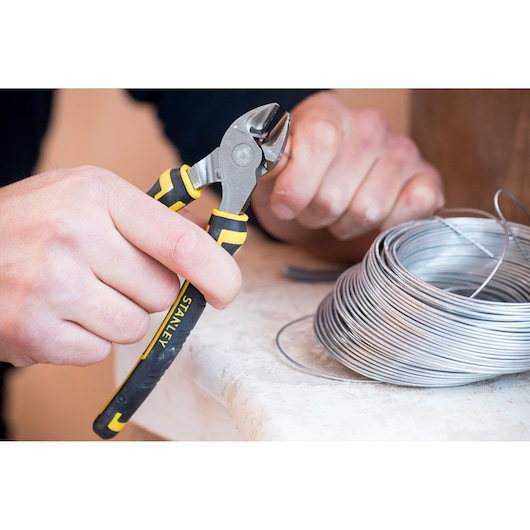 STANLEY 0-89-858 pince coupante utilisée pour couper du fil argenté, gros plan avec bobine sur table.