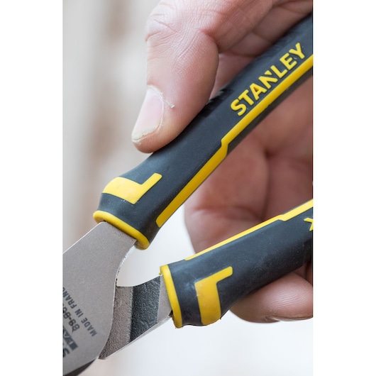 Close-up foto van STANLEY 0-89-868 tang met zwart-geel handvat, vastgehouden door een hand.