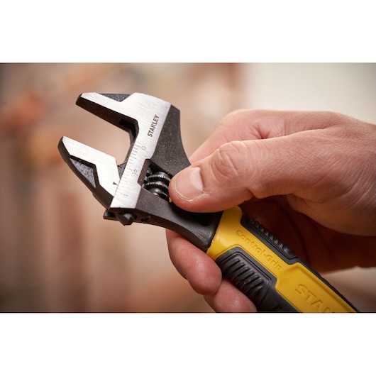 STANLEY 0-90-949 verstelbare moersleutel met geel-zwarte grip, vastgehouden in hand, close-up.