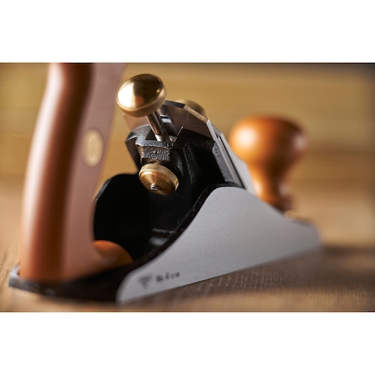 STANLEY 1-12-136 schaaf met houten en messing details, schuine close-up op gladde werkbank.