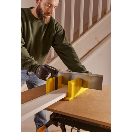 STANLEY 1-20-600 photographie boîte à onglets jaune et scie en utilisation menuiserie, angle latéral rapproché.
