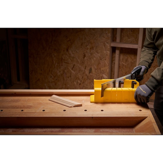 STANLEY 1-20-600 photographie de boîte à onglets jaune utilisée pour scier du bois sur un établi.