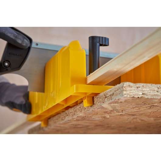 STANLEY 1-20-600 gele kunststof verstekbak en zaag zagen houten plank, close-up.
