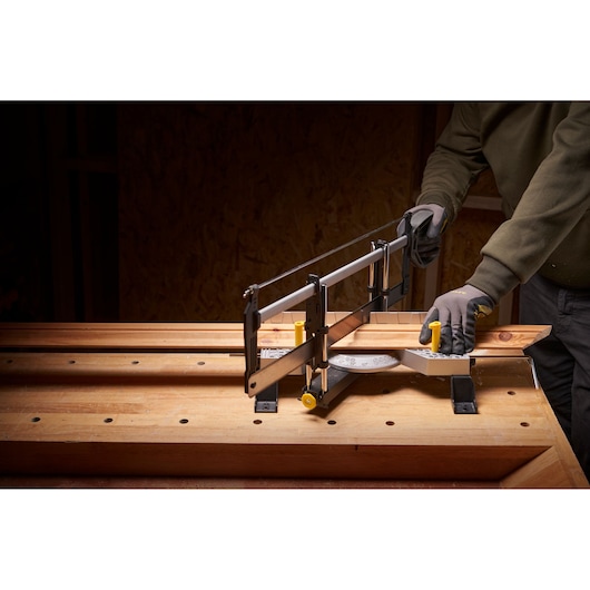 STANLEY 1-20-800 scie à onglets manuelle utilisée sur établi en bois, coupe une pièce de bois en angle.