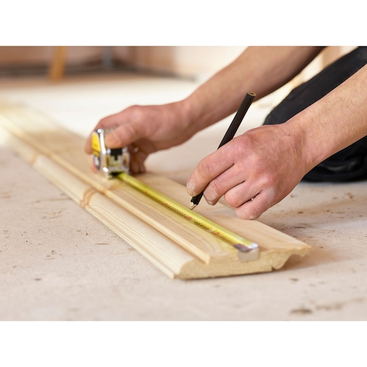STANLEY 1-33-198 rolmaat fotografie toont meten en markeren van houten plank.