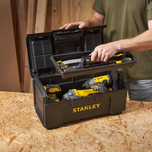 Boîte à outils STANLEY 1-79-217 avec outils électroportatifs jaunes et noirs, ouverte sur l’établi, vue en angle.