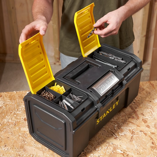 Boîte à outils noire STANLEY 1-79-217 avec couvercles jaunes, ouverte montrant des compartiments avec vis et forets.