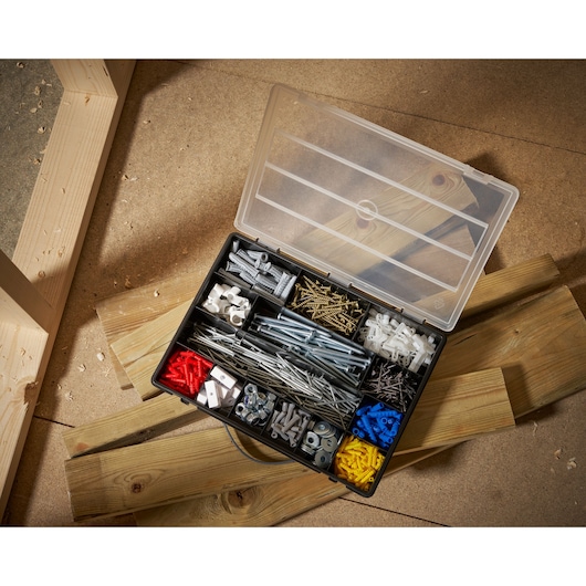 STANLEY 1-92-761 organizer box bovenaanzicht met diverse schroeven, pluggen, moeren en bouten op werkplaatsvloer.