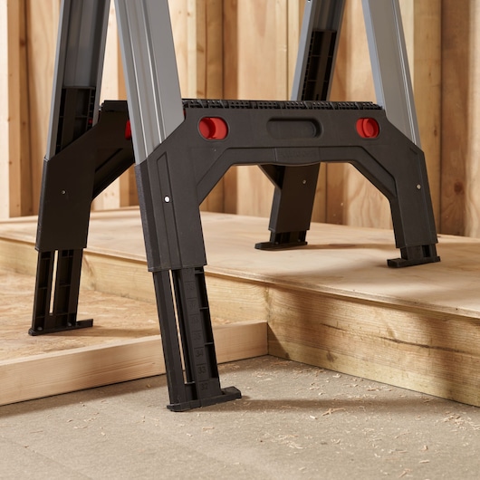 STANLEY 1-92-980 verstelbare werkplatformpoten met maataanduidingen, zijkant close-up, op houten vloer.
