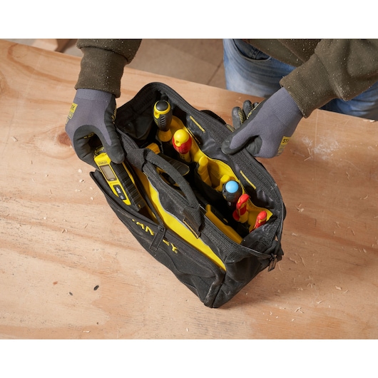 STANLEY 1-93-330 gereedschapstas met diverse handgereedschap, bovenaanzicht, op houten oppervlak.