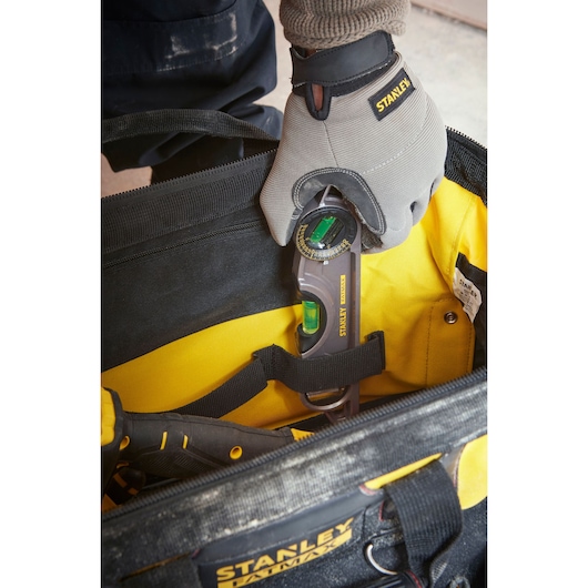 Photo du sac à outils STANLEY 1-93-950 avec un ouvrier plaçant un niveau digital d’angle, vue de dessus.