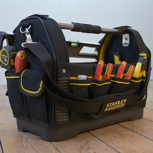 STANLEY 1-93-951 FATMAX gereedschapstas met gereedschap, zijaanzicht, zwart-geel op houten vloer.