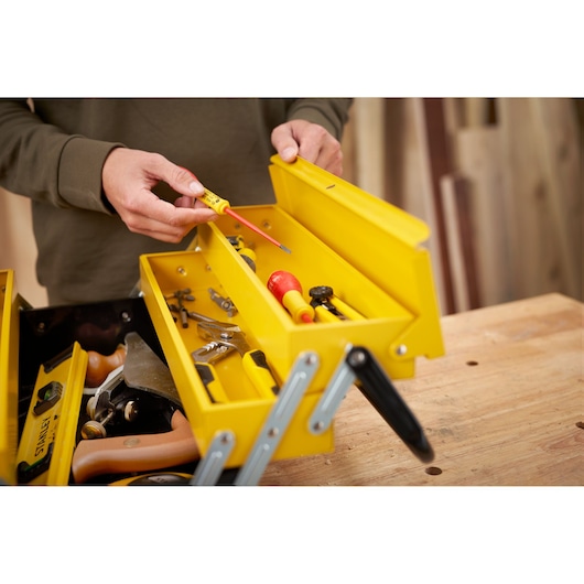 STANLEY 1-94-738 boîte à outils en métal jaune avec outils à main variés, photo prise d'en haut sur un établi.