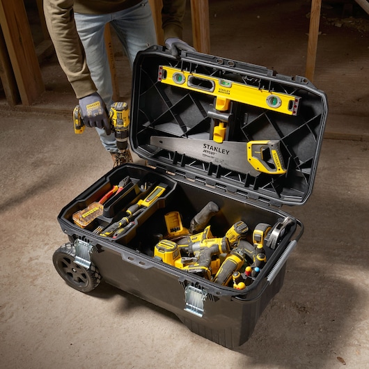 STANLEY 1-94-850 rolkist open, gevuld met handgereedschap en elektrisch gereedschap op bouwplaats.
