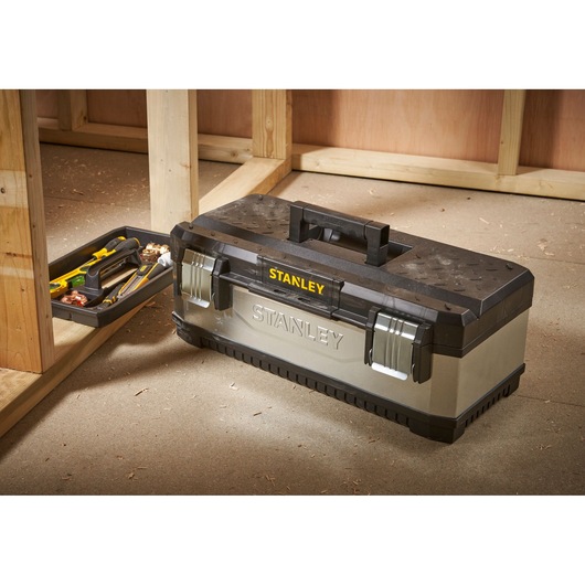 STANLEY 1-95-619 gereedschapskist met lade en gereedschap op werkplaatsvloer, zilver en zwart.