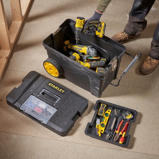 Photographie de boîte à outils STANLEY 1-97-503 avec roues jaunes et outils manuels et électriques assortis à l'intérieur.