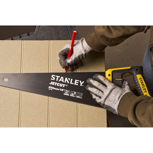 Fotografie van STANLEY 2-20-180 handzaag met geel-zwarte handgreep gebruikt voor markeren op plaat.