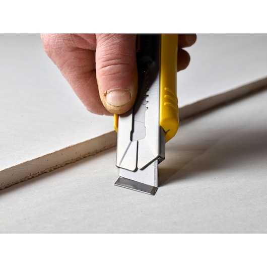 STANLEY 3-11-725 hobbymes met gele handgreep snijdt gipsplaat, close-up zijaanzicht.
