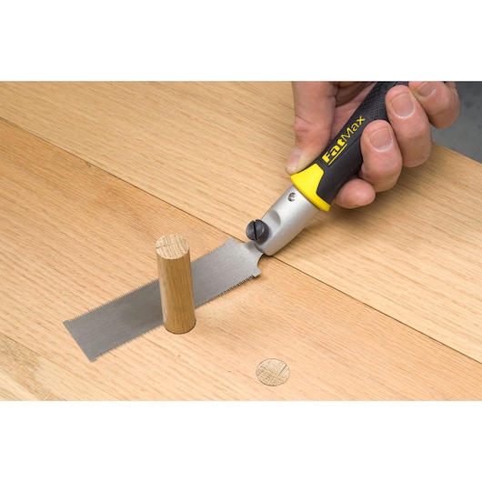 STANLEY 3-20-331 flush cut zaag met geel-zwarte handgreep zaagt houten deuvel op houten oppervlak.