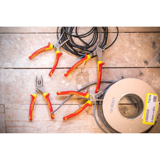 STANLEY 4-84-489 geïsoleerde tangen met rode en gele handgrepen op houten oppervlak met elektrische kabels.