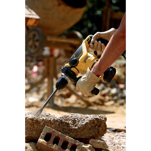 STANLEY FME1250K boorhamer in gebruik op beton op bouwplaats, close-up foto.