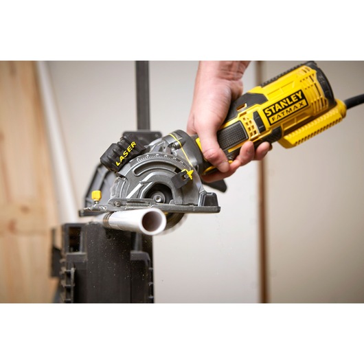 Photo de la scie STANLEY FME380K coupant un tube PVC, gros plan, design jaune et noir.