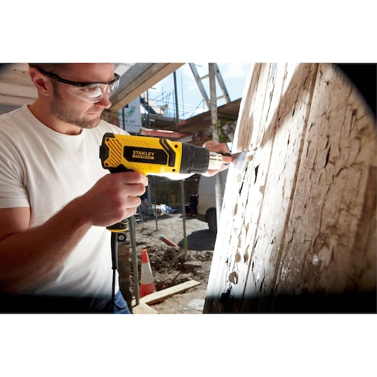 Photo du décapeur thermique STANLEY FME670K utilisé pour enlever la peinture sur bois sur chantier.