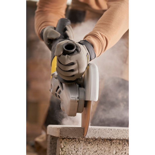 STANLEY FMEG232 meuleuse d’angle en utilisation, coupe de bloc de pierre, photographie en gros plan.