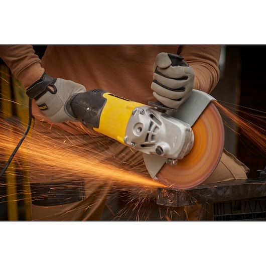 STANLEY FMEG232 meuleuse d’angle utilisée pour couper du métal, corps jaune et noir, étincelles.