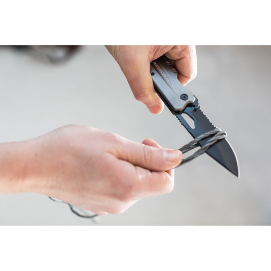 Couteau pliant STANLEY FMHT0-10312 coupant du fil, vue rapprochée des mains utilisant le couteau.
