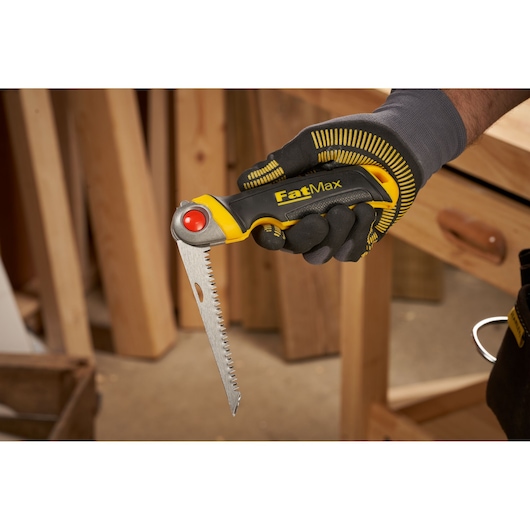 STANLEY FMHT0-20559 FatMax vouwzaag met geel-zwarte handgreep in gehandschoende hand, zijaanzicht.