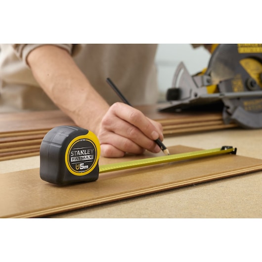 STANLEY FMHT0-33864 rolmaat gebruikt voor hout markeren, geel-zwarte behuizing, close-up fotografie.