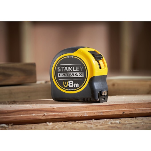 STANLEY FMHT0-33868 FATMAX magnetische rolmaat, 8m, zwart-geel, zijaanzicht, op houten oppervlak.