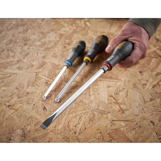 STANLEY FMHT0-62621 schroevendraaierset met zwarte handgrepen, platte en kruiskop, schuin op hout.
