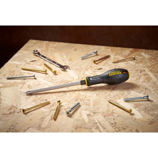STANLEY FMHT0-62623 tournevis à manche noir et jaune sur surface en bois entouré de vis et d'une clé.