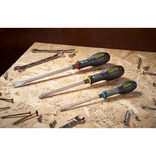 STANLEY FMHT0-62623 ensemble de tournevis à poignées noires sur établi en bois avec vis et clés.