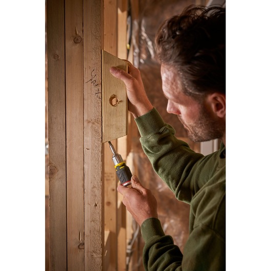 STANLEY FMHT0-62688 tournevis utilisé pour fixer un panneau en bois sur une structure en bois.