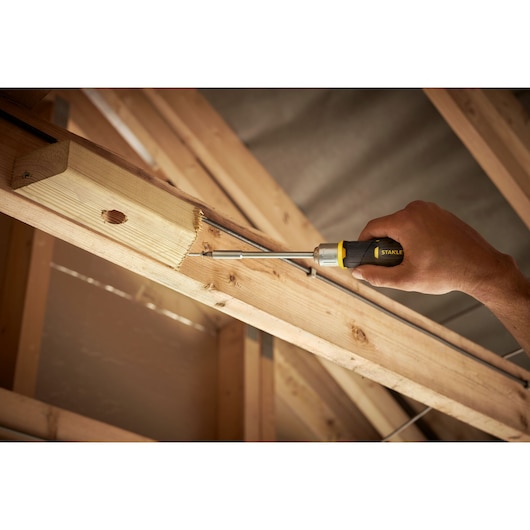 STANLEY FMHT0-62691 tournevis utilisé sur poutre en bois, angle latéral, photo produit en chantier.